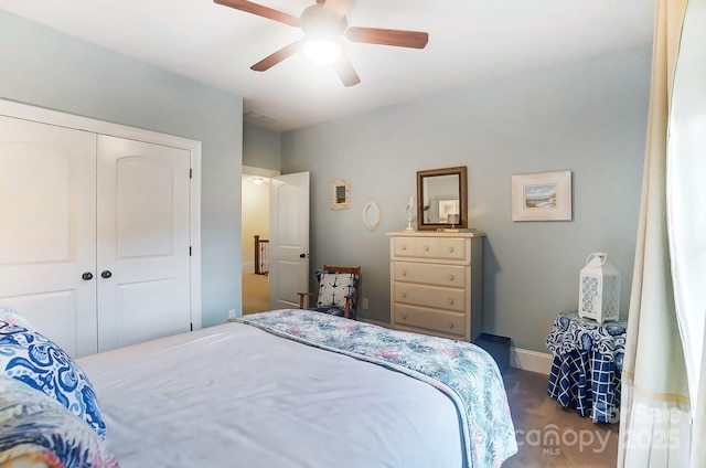 bedroom featuring ceiling fan, a closet, and dark colored carpet