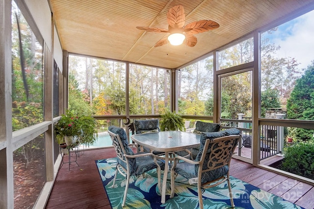 sunroom featuring a wealth of natural light, wooden ceiling, and ceiling fan