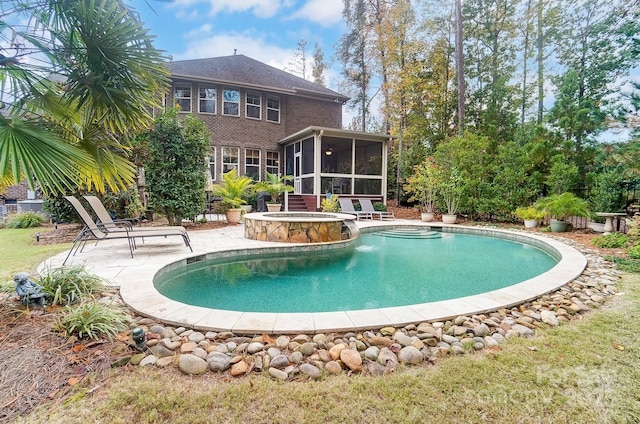 view of pool with an in ground hot tub, a patio, and a sunroom