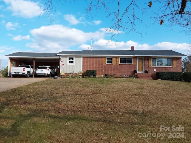 view of front of home with a carport and a front lawn