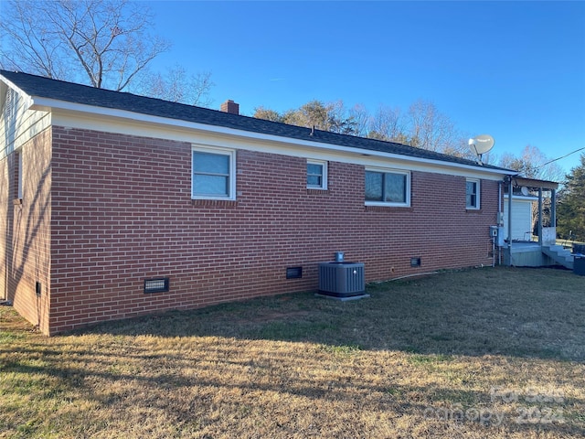 view of side of property with a yard and central air condition unit