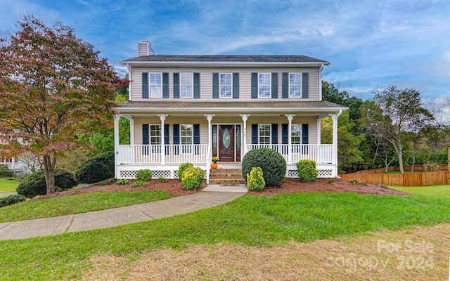 colonial-style house with a front lawn and covered porch