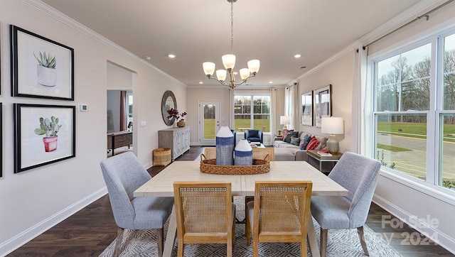 dining space with dark hardwood / wood-style flooring, plenty of natural light, ornamental molding, and an inviting chandelier