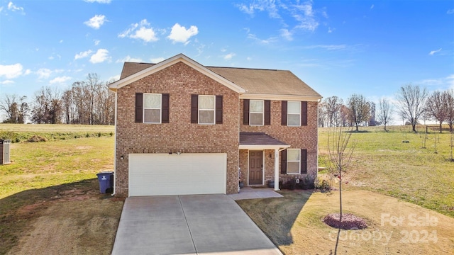 view of front of house with a garage and a front lawn