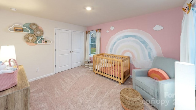 bedroom with a crib, carpet flooring, and a closet