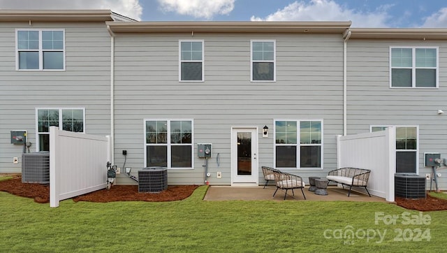 back of property with a yard, a patio area, and central air condition unit