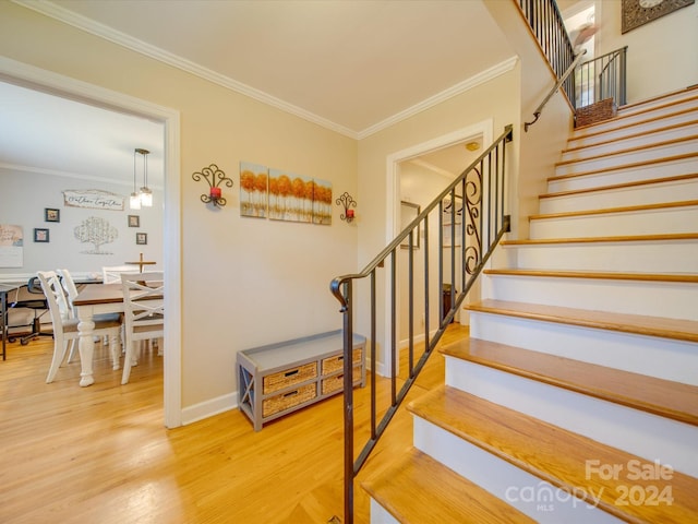 staircase featuring hardwood / wood-style floors and ornamental molding