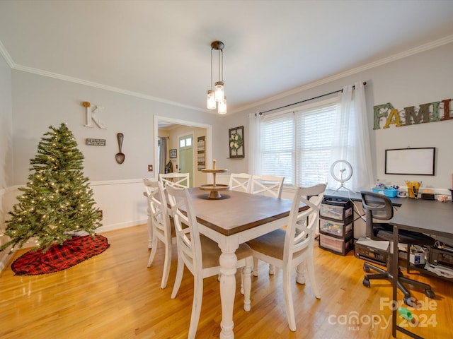 dining room featuring light wood-type flooring and crown molding