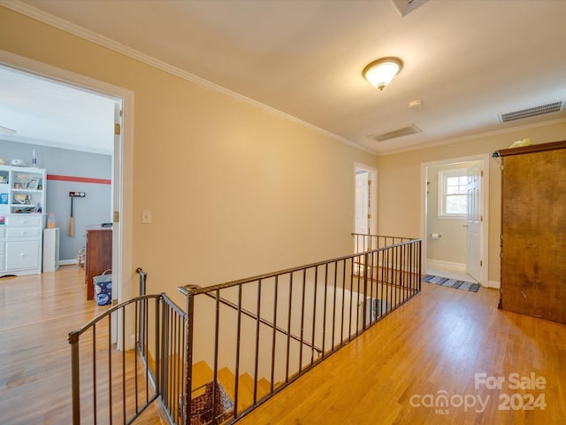 hallway featuring ornamental molding and light hardwood / wood-style flooring