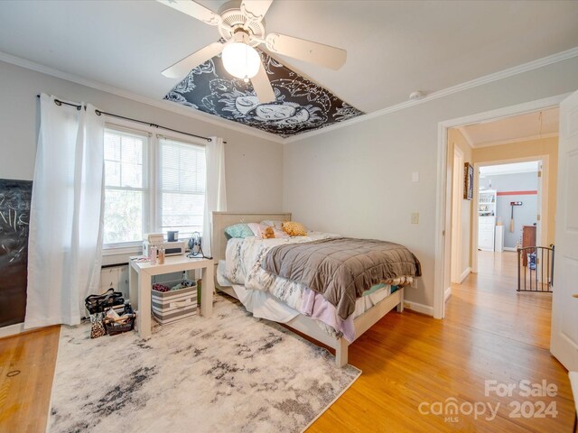 bedroom with hardwood / wood-style flooring, ceiling fan, and crown molding