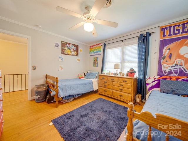 bedroom with ceiling fan, wood-type flooring, and ornamental molding