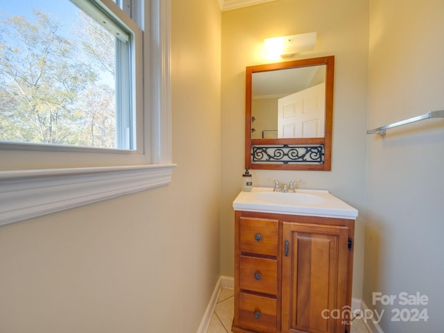 bathroom featuring tile patterned floors, crown molding, and vanity