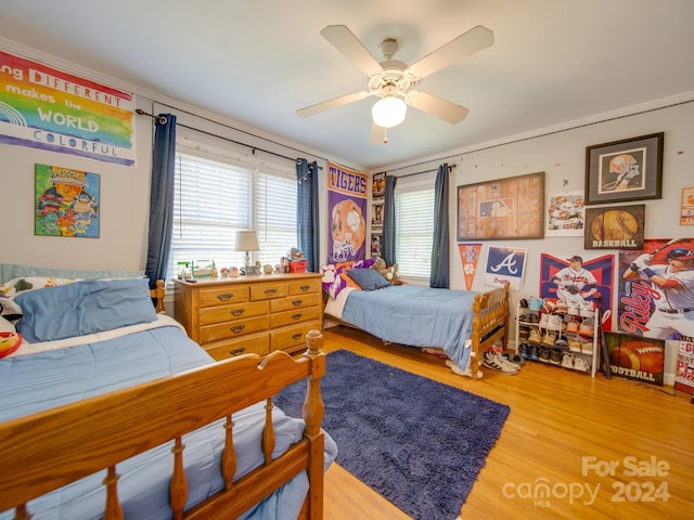 bedroom featuring hardwood / wood-style floors, ceiling fan, and ornamental molding