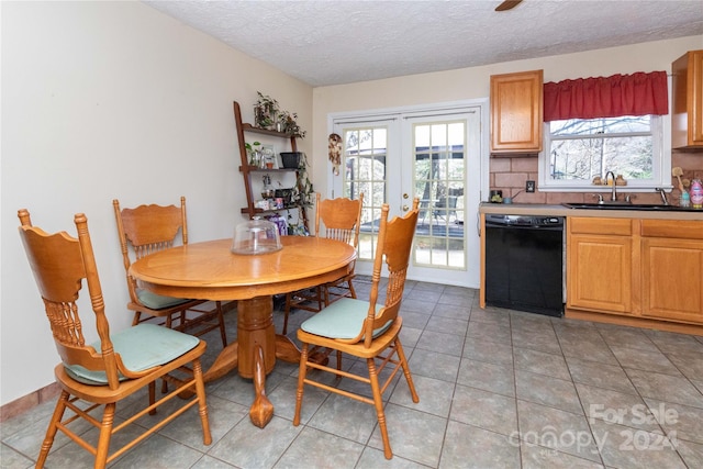 dining room featuring a healthy amount of sunlight, light tile patterned floors, sink, and french doors