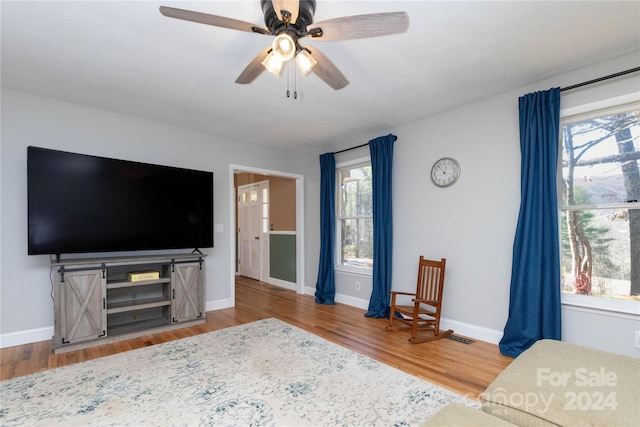 living room featuring hardwood / wood-style floors and ceiling fan