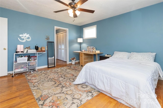 bedroom featuring ceiling fan, a closet, and hardwood / wood-style flooring