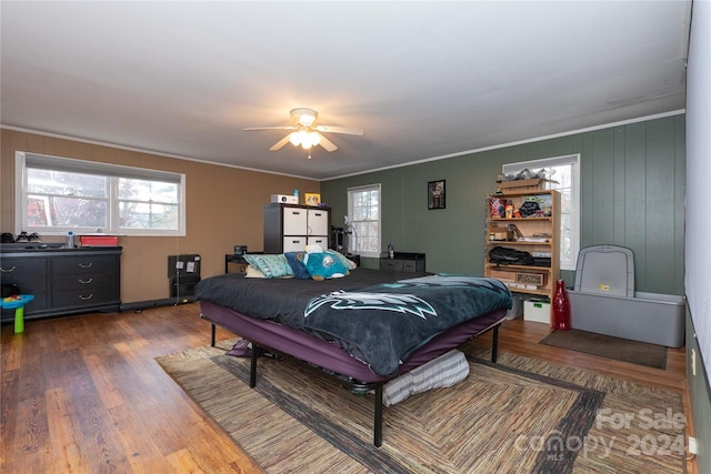 bedroom featuring ceiling fan, crown molding, and wood-type flooring