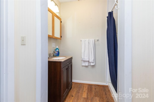 bathroom with wood-type flooring, vanity, and curtained shower