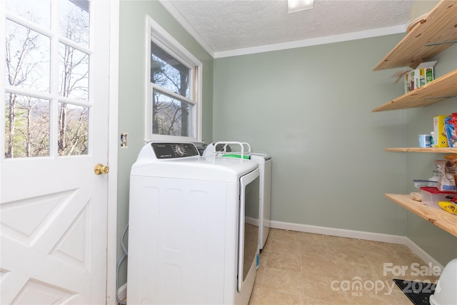 laundry room featuring independent washer and dryer, a textured ceiling, and light tile patterned flooring