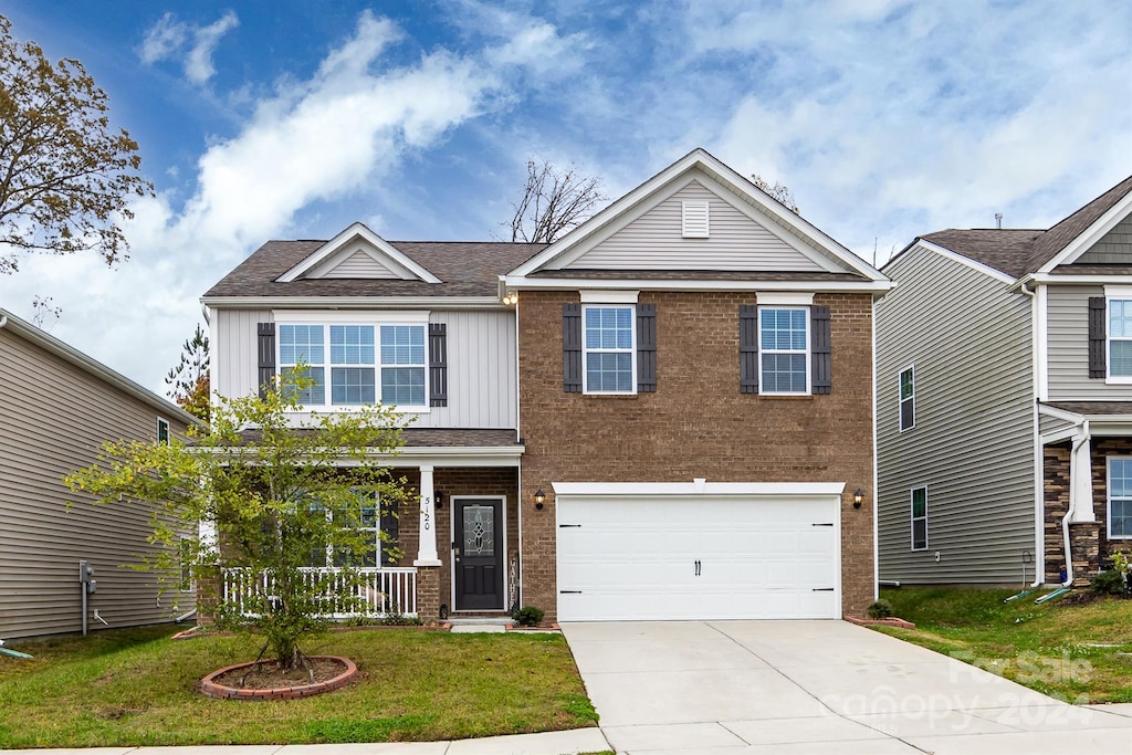 view of front of property with a front yard and a garage