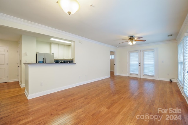 unfurnished living room with ceiling fan, french doors, crown molding, and light hardwood / wood-style flooring