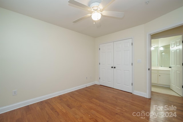 unfurnished bedroom featuring ceiling fan, a closet, and hardwood / wood-style flooring