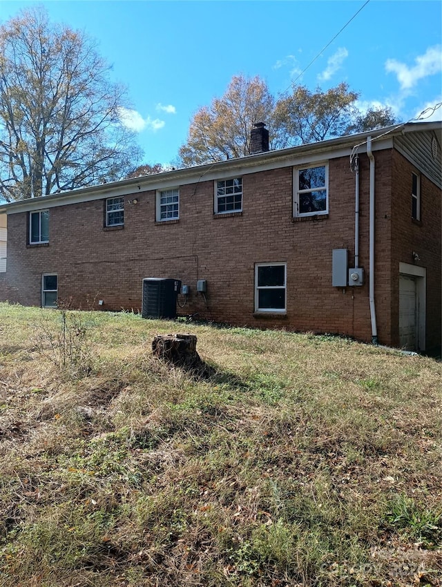 back of house with central AC unit