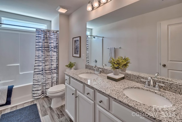 full bathroom featuring hardwood / wood-style floors, vanity, toilet, and shower / bath combo