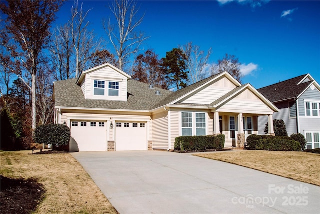 view of front of house featuring a porch, a front yard, and a garage