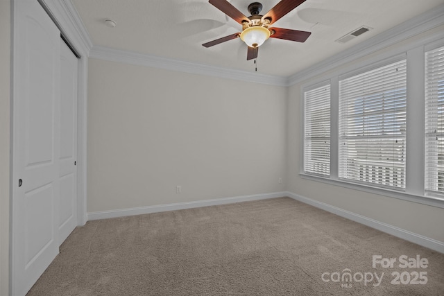 unfurnished bedroom featuring ceiling fan, crown molding, light carpet, and a closet