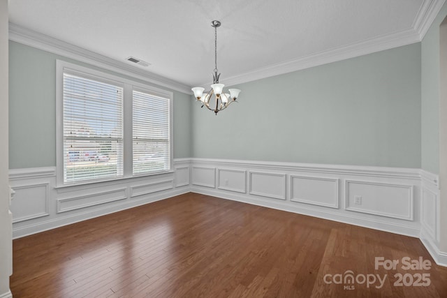 spare room featuring crown molding, a wealth of natural light, and a notable chandelier