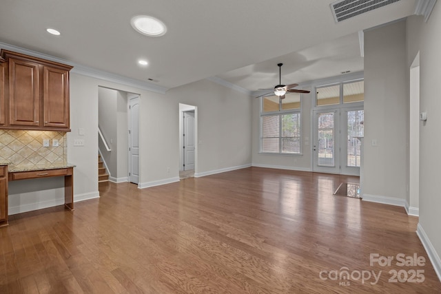 unfurnished living room featuring ceiling fan, light hardwood / wood-style floors, and ornamental molding