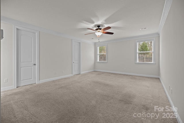 carpeted spare room featuring ceiling fan and crown molding