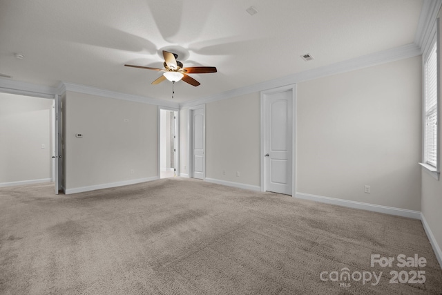 carpeted spare room with ceiling fan and ornamental molding