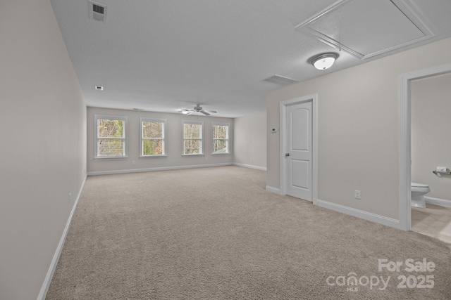 spare room featuring a textured ceiling, ceiling fan, and light carpet