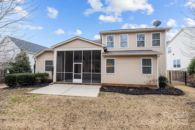 rear view of house with a sunroom, a yard, and a patio