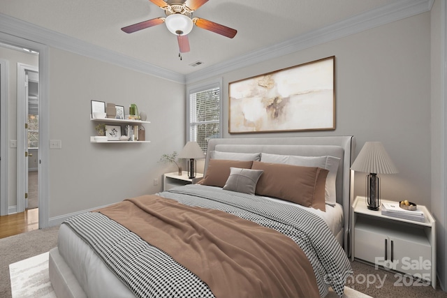 carpeted bedroom featuring ceiling fan and crown molding