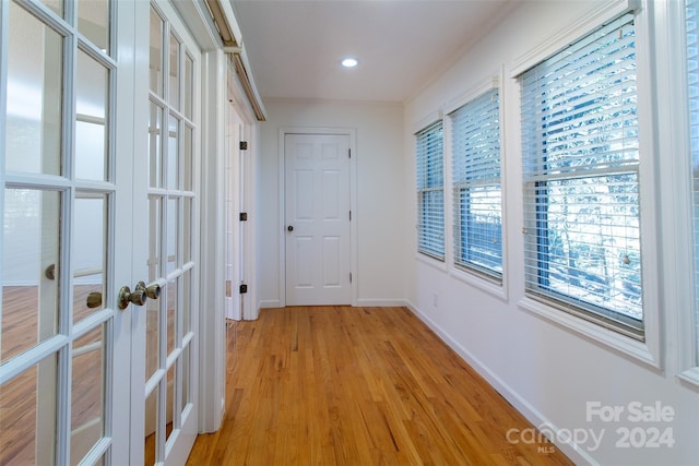 hallway featuring french doors and light hardwood / wood-style flooring