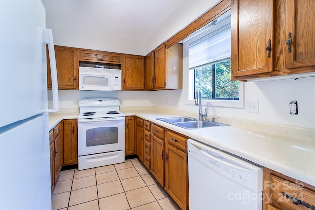 kitchen with sink, light tile patterned floors, and white appliances