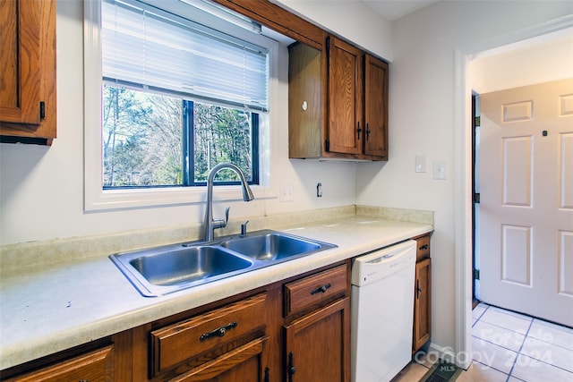 kitchen featuring dishwasher, light tile patterned floors, and sink