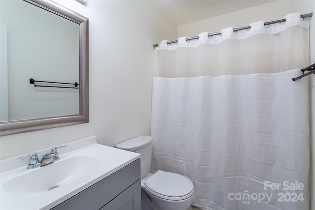 bathroom with vanity, toilet, and a textured ceiling