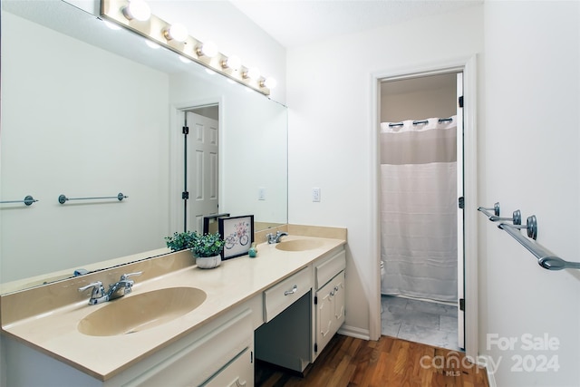 bathroom with hardwood / wood-style floors, vanity, and walk in shower