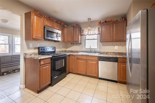 kitchen featuring decorative light fixtures, sink, stainless steel appliances, and plenty of natural light