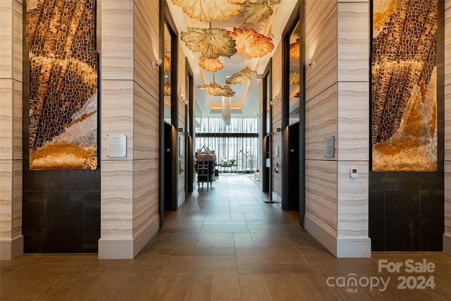 hall with tile patterned flooring and tile walls