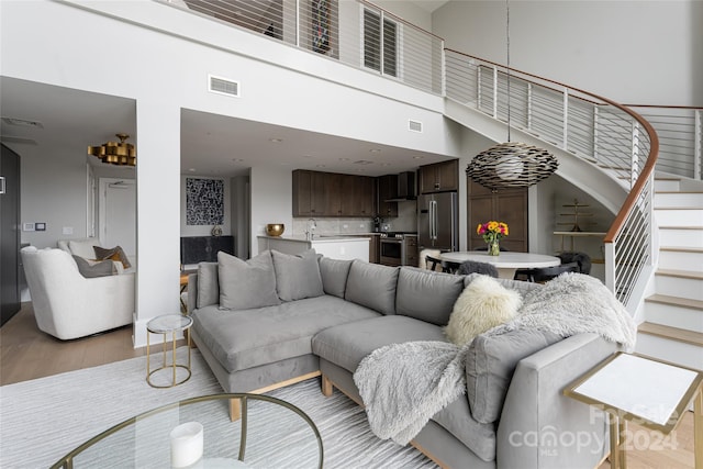 living room featuring light hardwood / wood-style flooring and a high ceiling