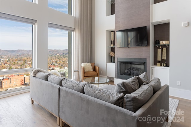 living room featuring a mountain view, a towering ceiling, and light hardwood / wood-style floors