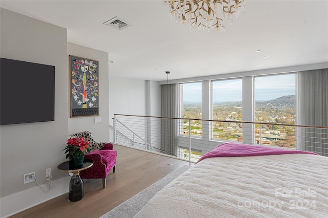 bedroom featuring a mountain view, hardwood / wood-style flooring, and a notable chandelier