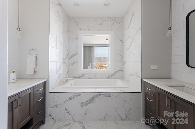 bathroom featuring tiled tub and vanity