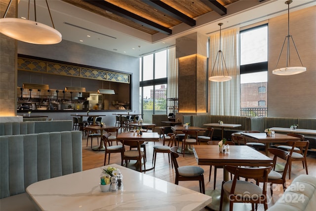 dining area with plenty of natural light, light wood-type flooring, and a high ceiling