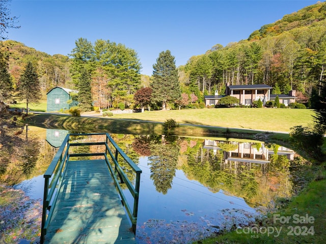 dock area with a water view and a lawn